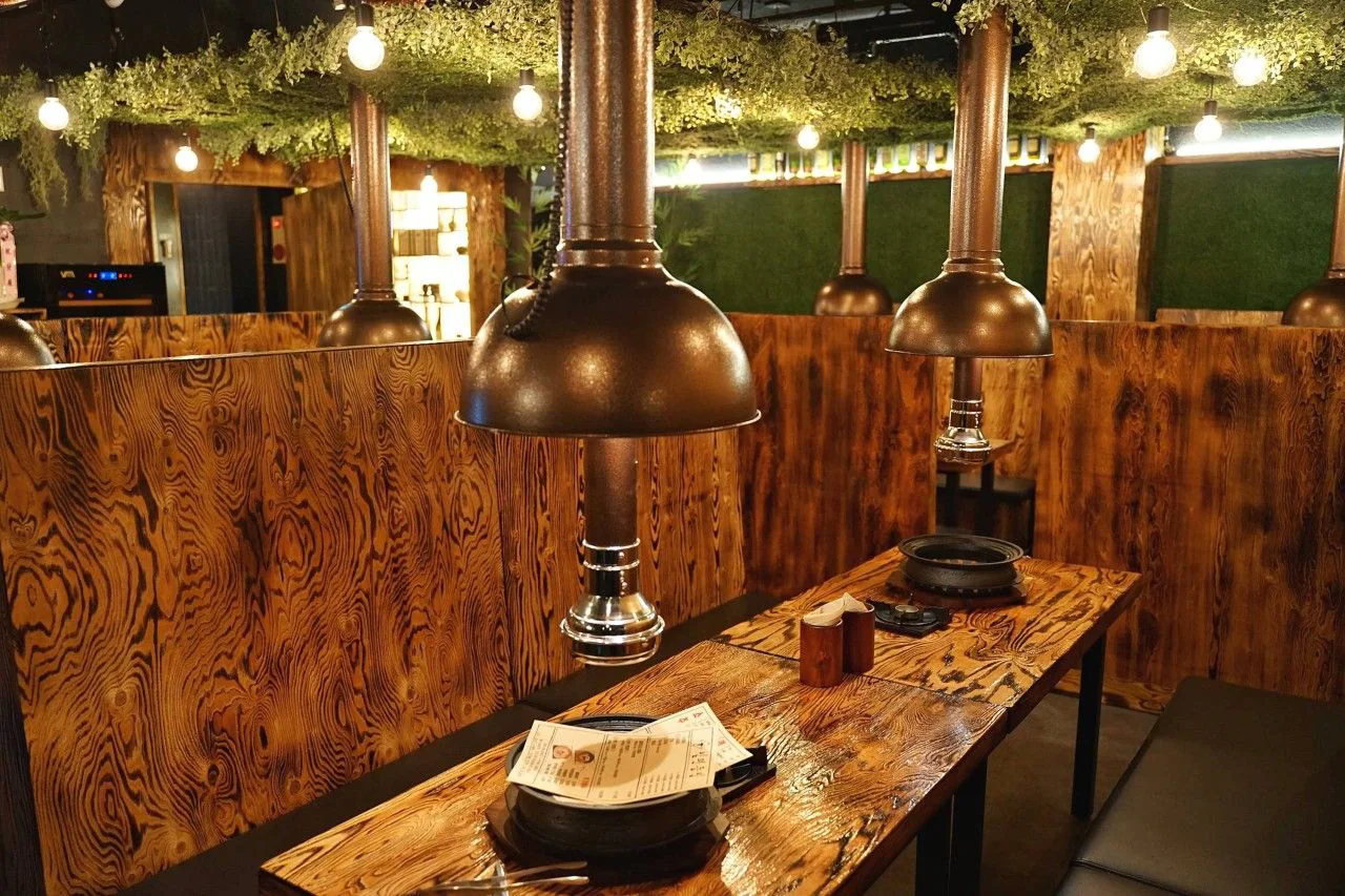 Scorched-wood booth tables with copper hoods